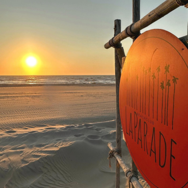 Zonsondergang aan zee bij Beachclub LaParade met een oranje bord op de voorgrond.
